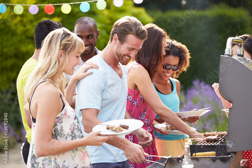 Group Of Friends Having Outdoor Barbeque At Home photo