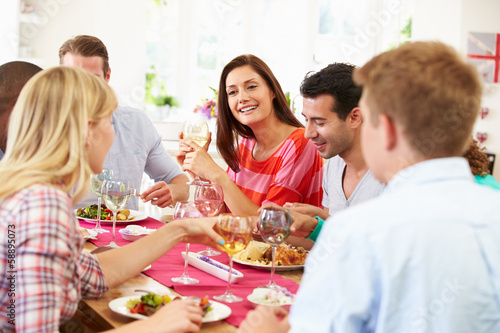 Group Of Friends Sitting Around Table Having Dinner Party