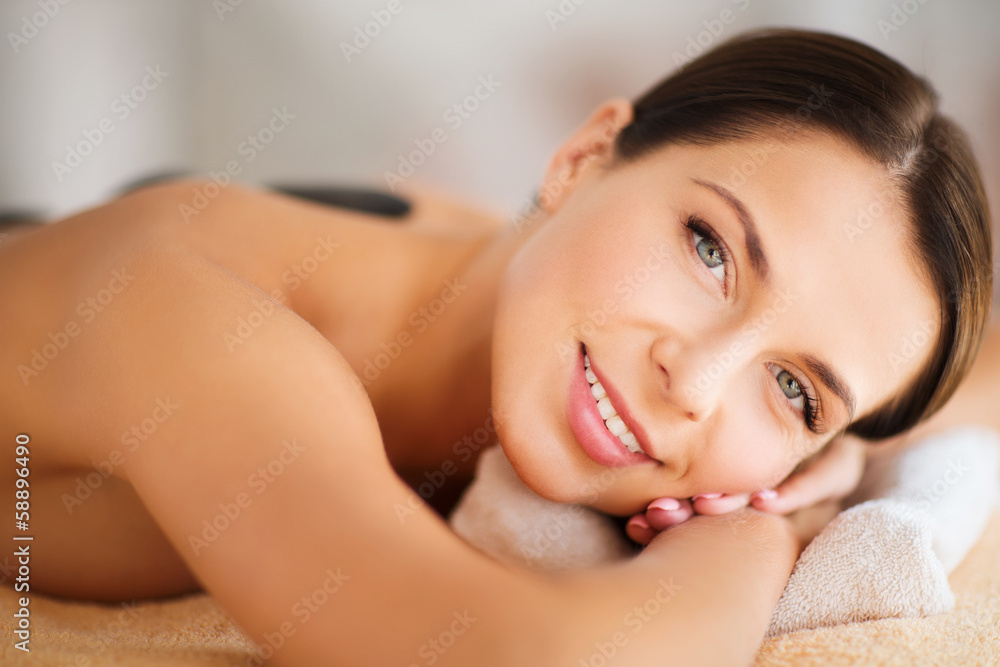 beautiful woman in spa salon with hot stones