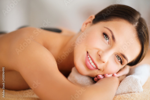 beautiful woman in spa salon with hot stones