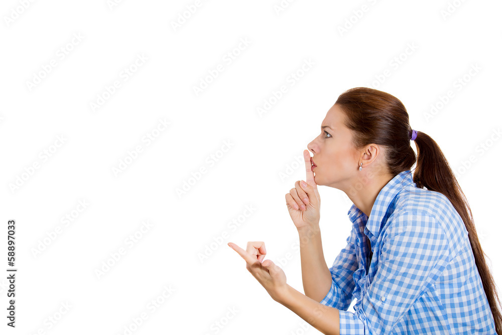 Closeup side view profile of young woman asking to be quiet Closeup side view profile of young woman asking to be quiet