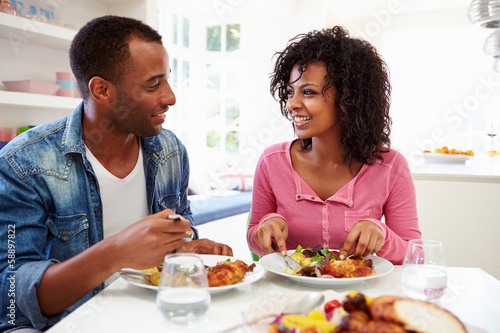 Young African American Couple Eating Meal At Home photo
