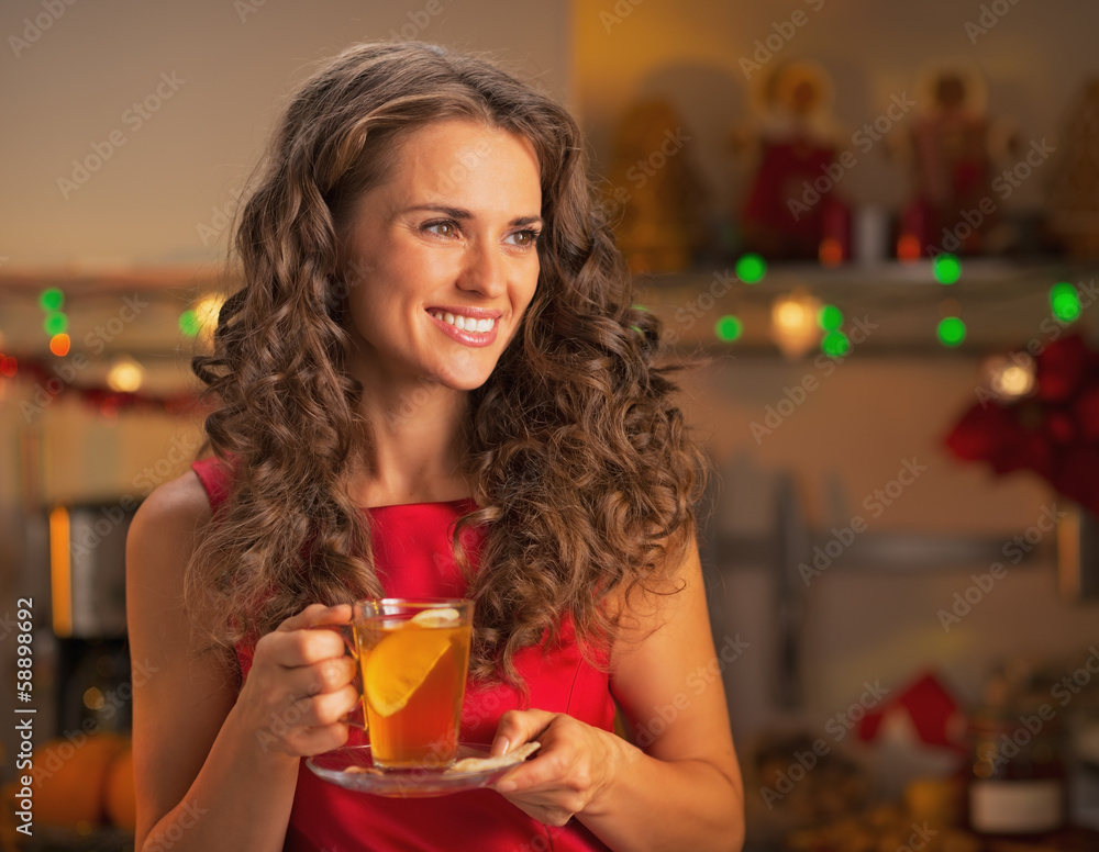 Happy young woman with cup of ginger tea looking on copy space Happy young woman with cup of ginger tea looking on copy space
