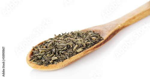Green dry tea in a wooden spoon