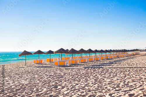 Empty beach with closed umbrellas in the early morning on