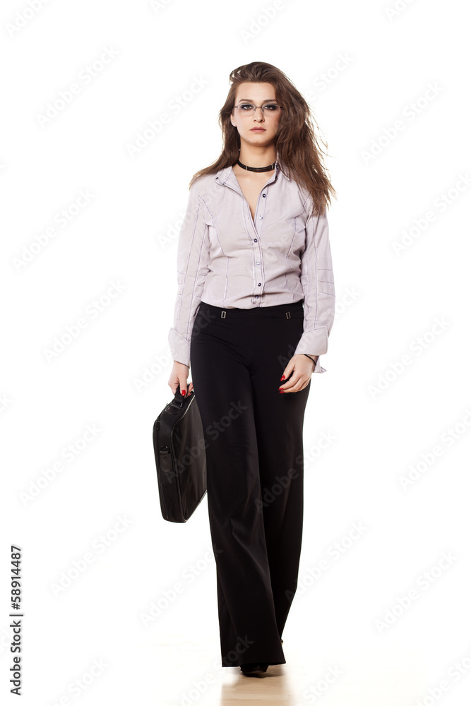 young businesswoman walking in trousers with laptop bag young businesswoman walking in trousers with laptop bag