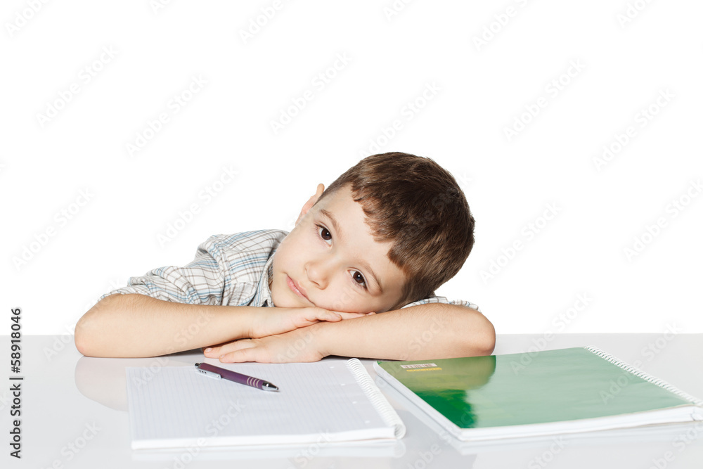 Little boy lying on the table with exercise books and thinking. Little boy lying on the table with exercise books and thinking.