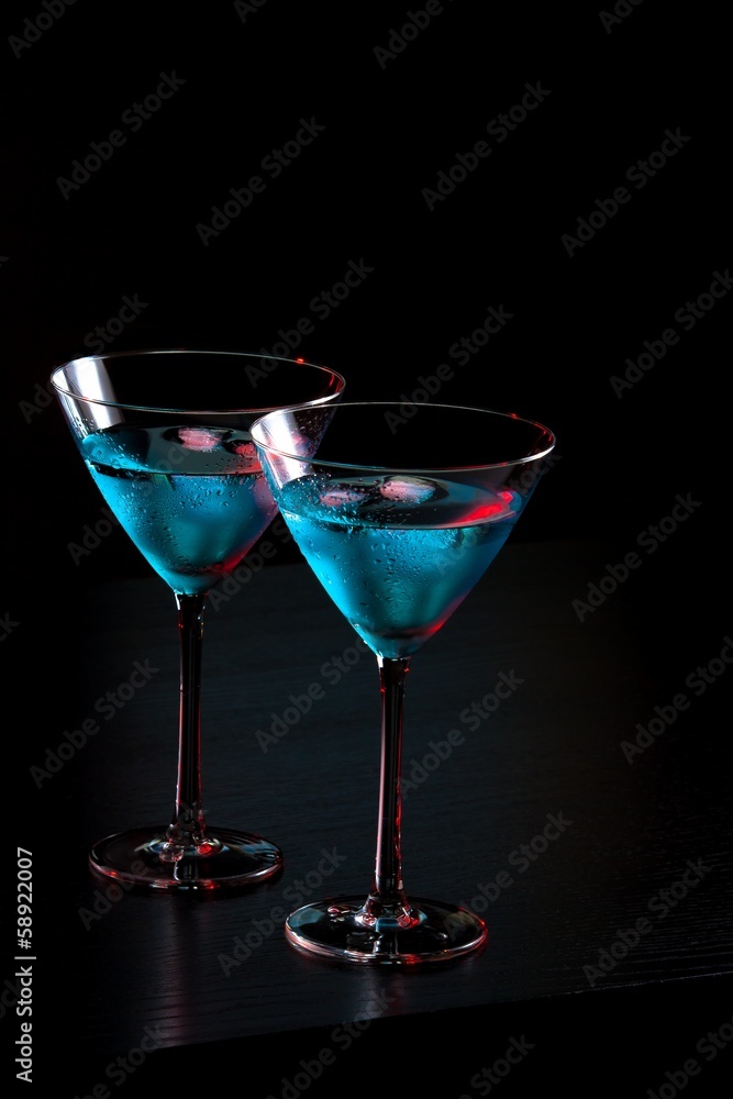 glasses of fresh blue cocktail with ice on bar table glasses of fresh blue cocktail with ice on bar table