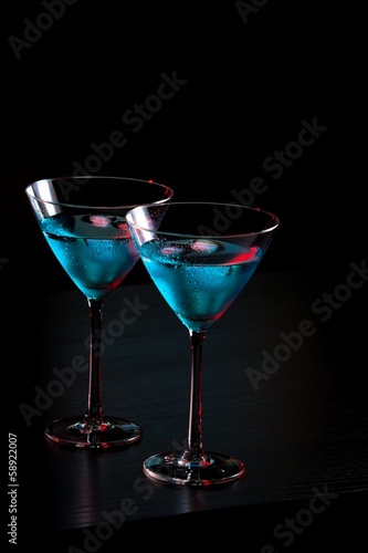 glasses of fresh blue cocktail with ice on bar table