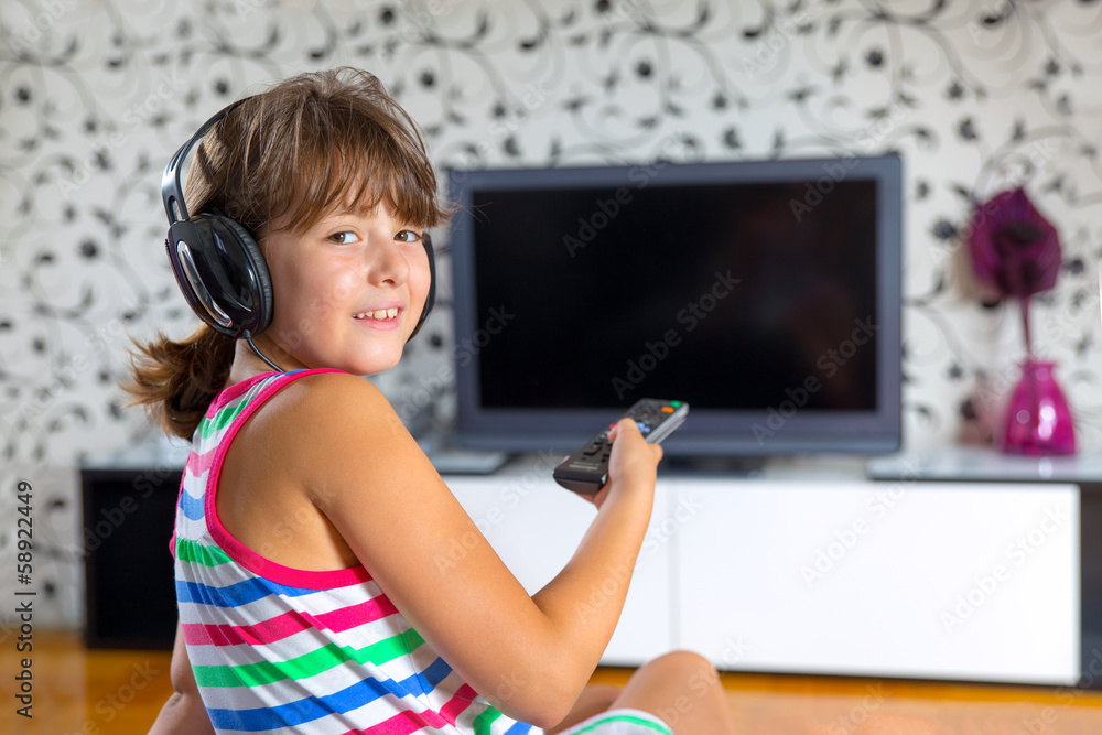 girl listening to music with headphones and watching tv Stock