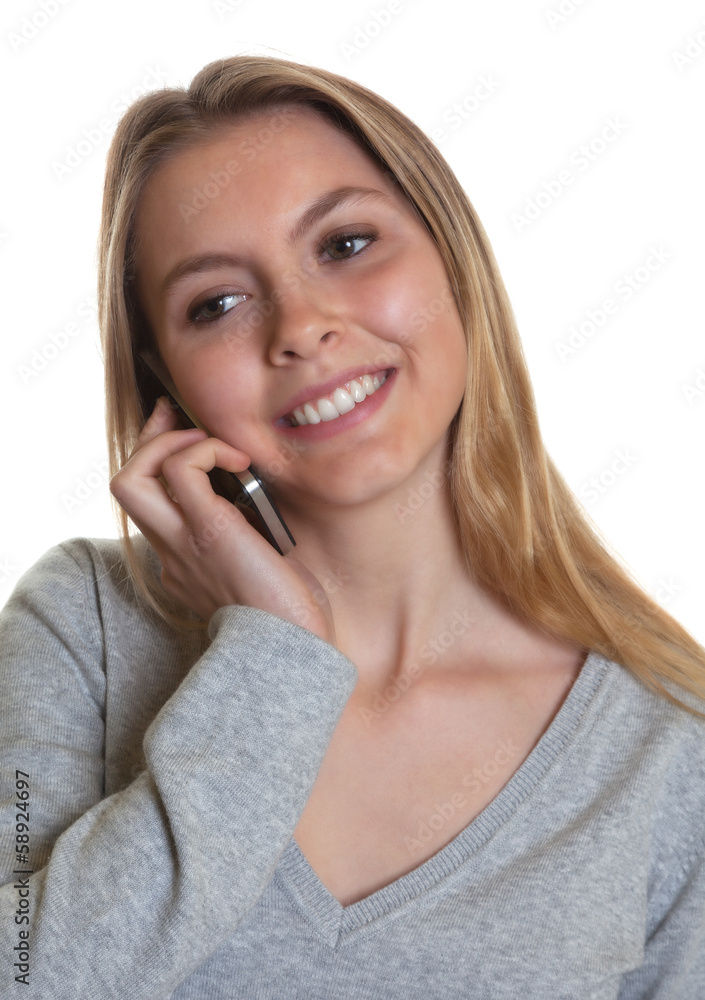 Junge Frau im grauen Pulli lacht am Telefon Junge Frau im grauen Pulli lacht am Telefon