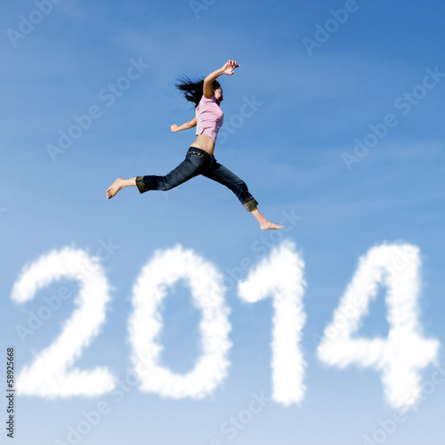 Woman jumping with new year 2014 of clouds