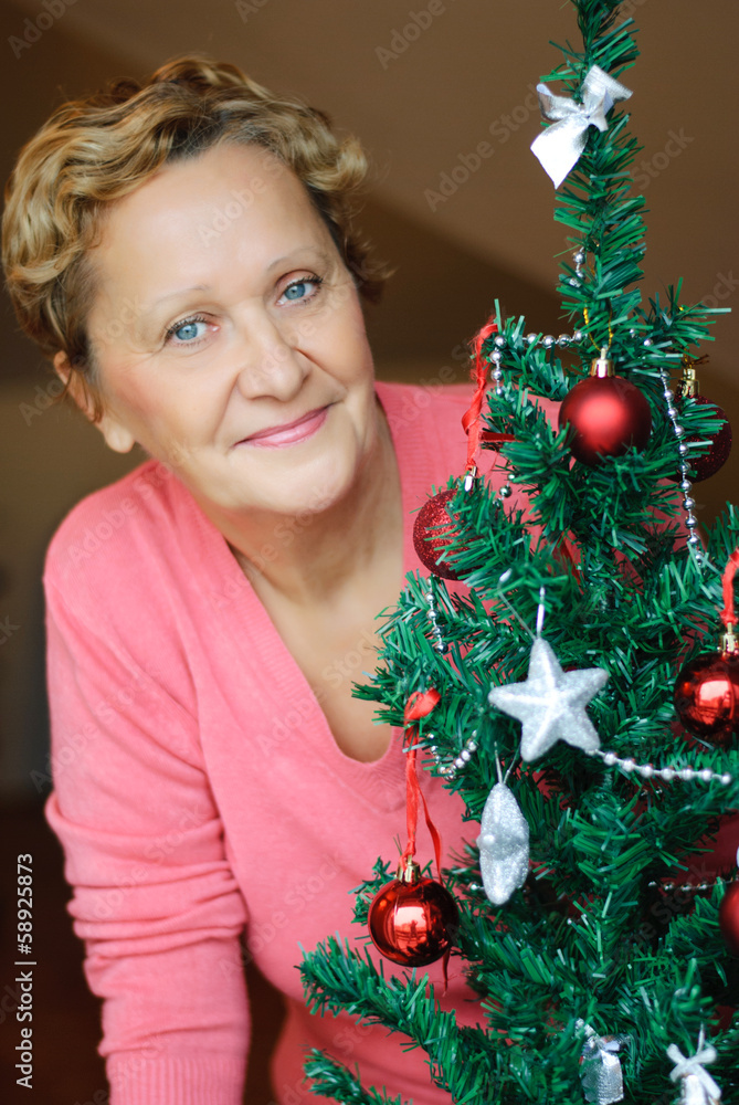 beautiful woman standing beside a Christmas tree