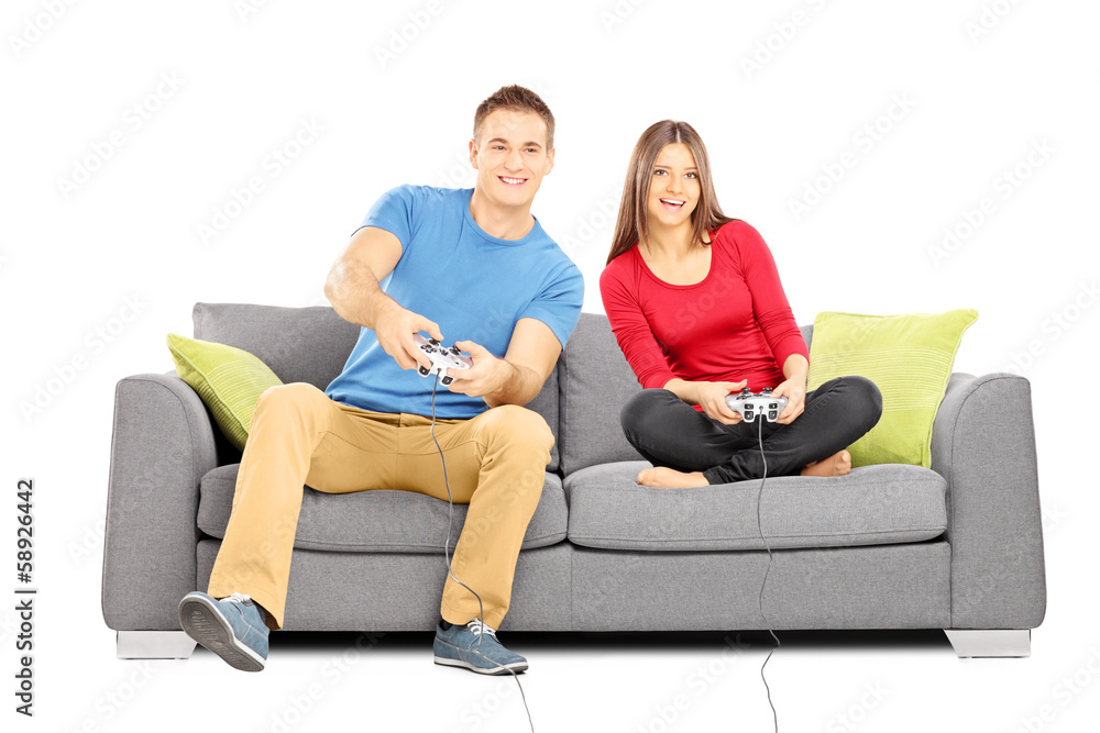 Young couple sitting on a modern couch and playing video games Young couple sitting on a modern couch and playing video games