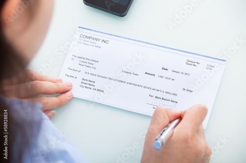 Businesswoman Signing On Cheque