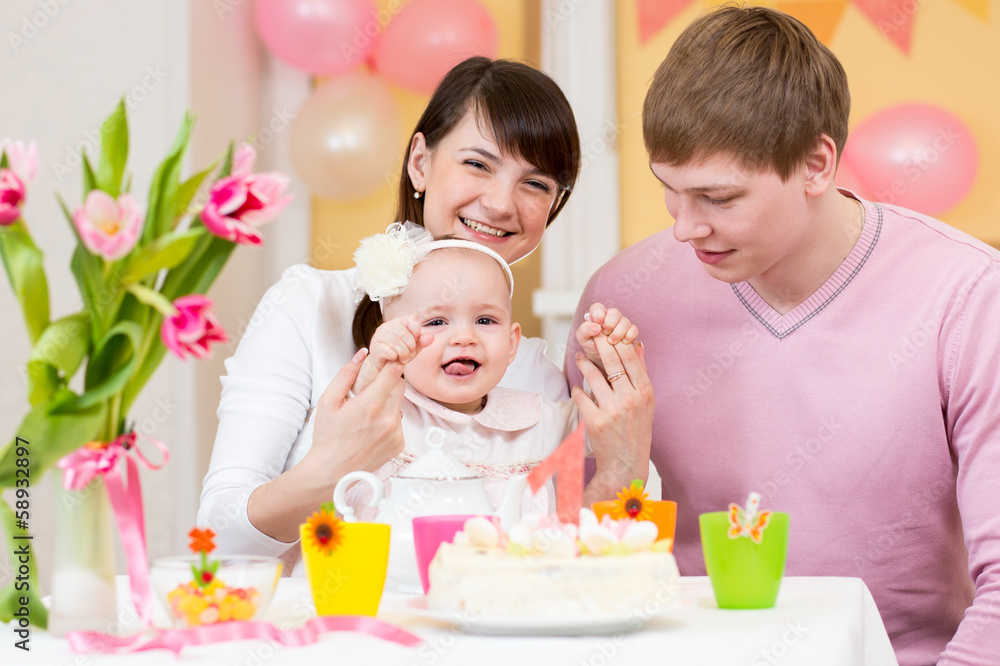 young family celebrating first birthday of baby girl young family celebrating first birthday of baby girl