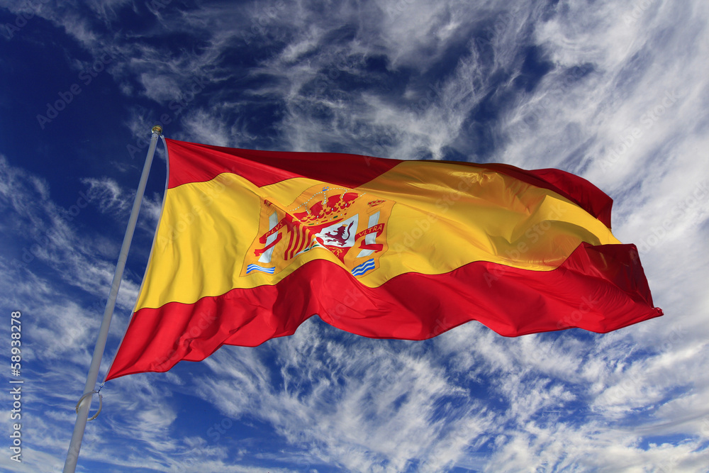 Spanish flag waving in the wind against a blue sky with clouds Spanish flag waving in the wind against a blue sky with clouds