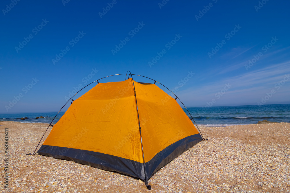 yellow touristic tent on a sandy beach