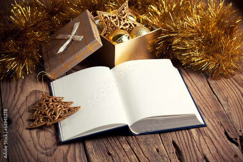 open book with christmas decoration on wooden background photo