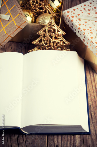 open book with christmas decoration on wooden background