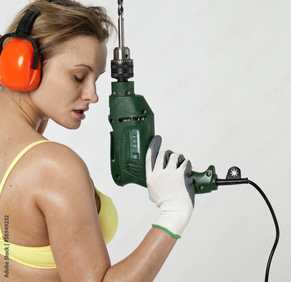 Sexy woman holding a construction drill Sexy woman holding a construction drill