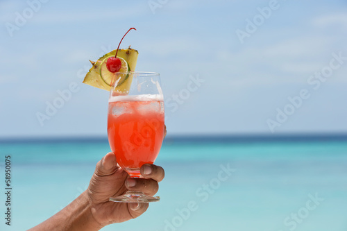 hand with cocktail glass near sea beach