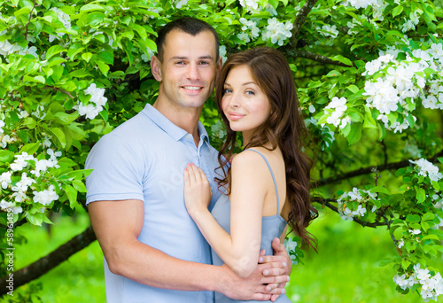 Couple embracing near blossomed tree in the park