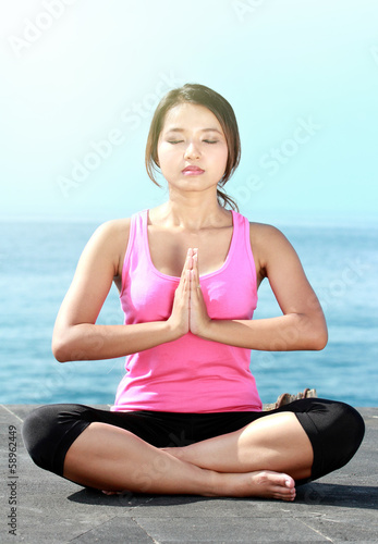 girl doing meditation on the beach