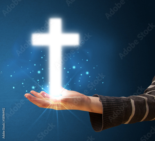 Glowing cross in the hand of a woman