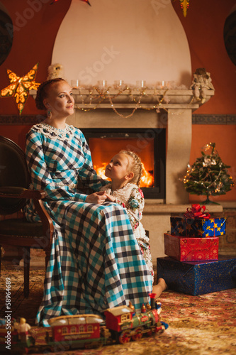 Family is by fireplace among Christmas decoration photo