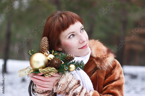 Happy girl with Christmas toy. winter forest background