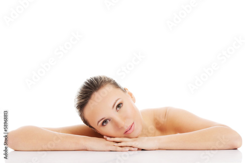 Beautiful nude woman is lying on her hands.