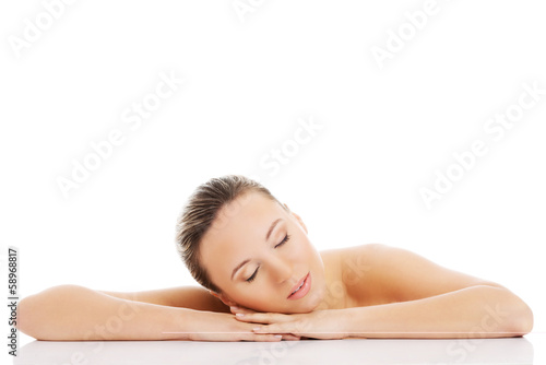 Beautiful nude woman is lying on her hands.