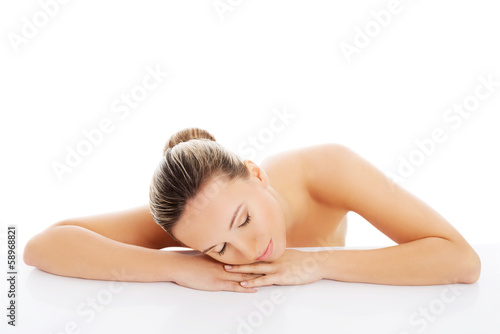 Beautiful nude woman is lying on her hands.