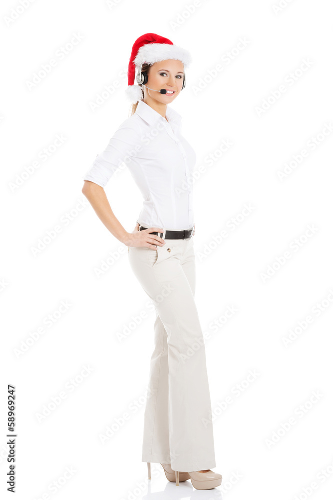 Young business woman in santa hat, microphone and headphones. Young business woman in santa hat, microphone and headphones.