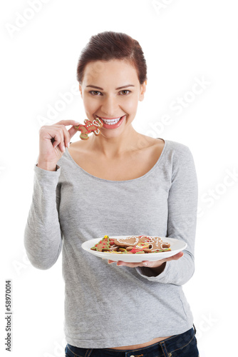 Beautiful young woman with cookies on a plate.