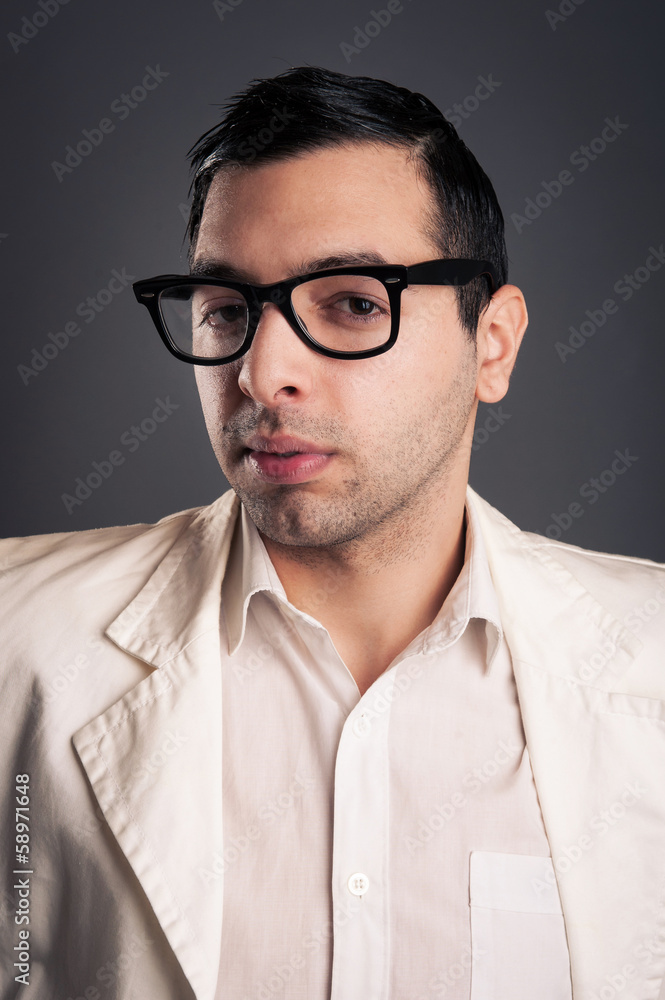 Fototapeta premium Portrait of young nerd with eyeglasses on grey background.