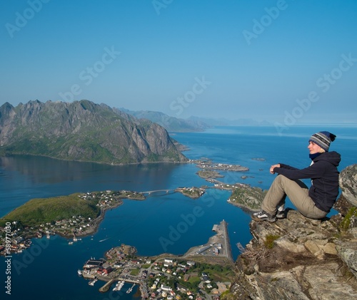 Woman hiker looking at Reine village panorama, Norway