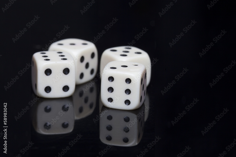 Four white dices in a black background
