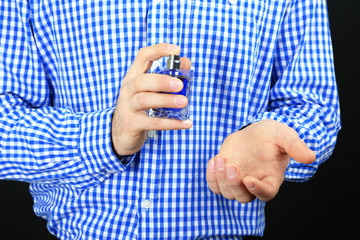 Fototapete Schönheitssalon Charismatischer Herr mit Duftflakon dunkel  © Africa Studio