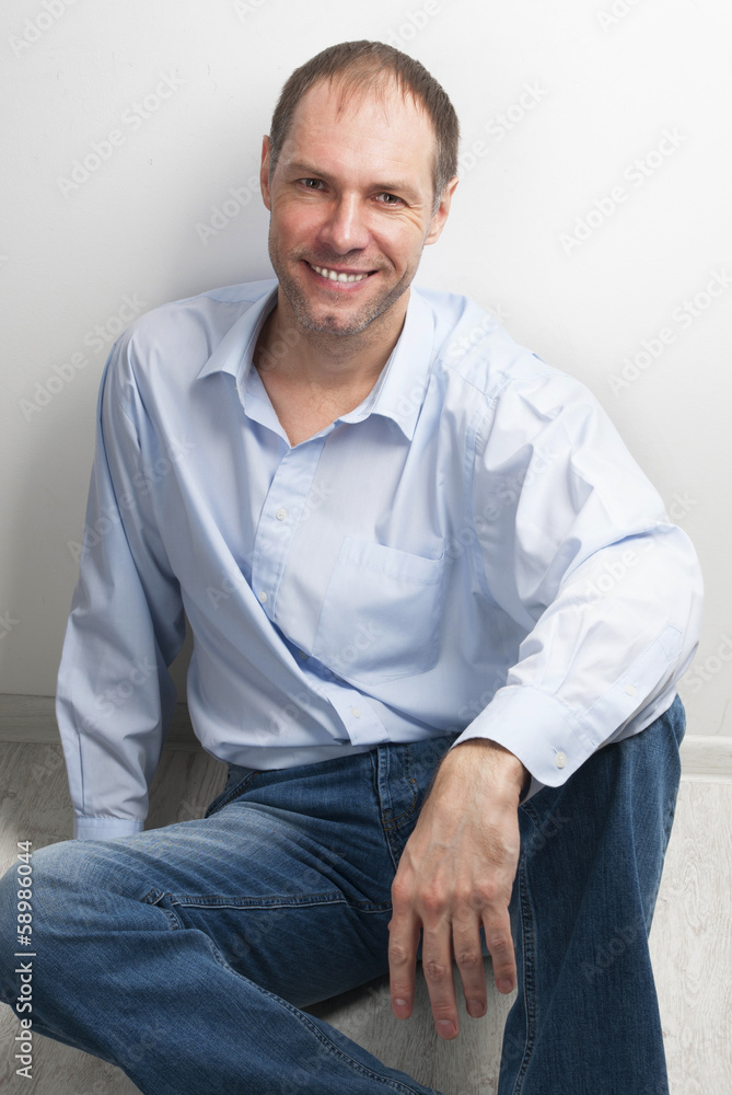 Portrait of smiling man sitting on the floor Portrait of smiling man sitting on the floor