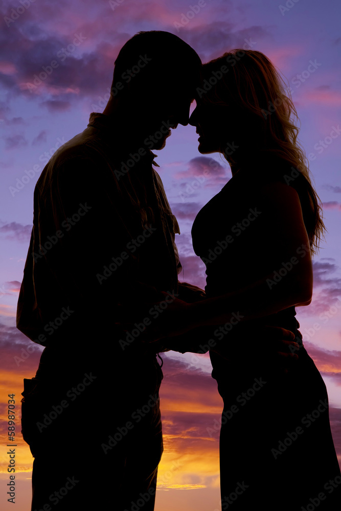 silhouette of couple heads together