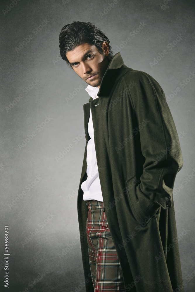 Male fashion model in green coat and texture backdrop