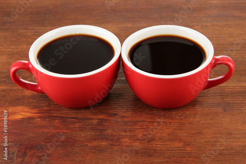 Red cups of strong coffee on wooden background