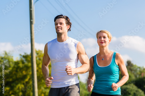 Fototapeta Naklejka Na Ścianę i Meble -  Sport couple running and jogging on rural street