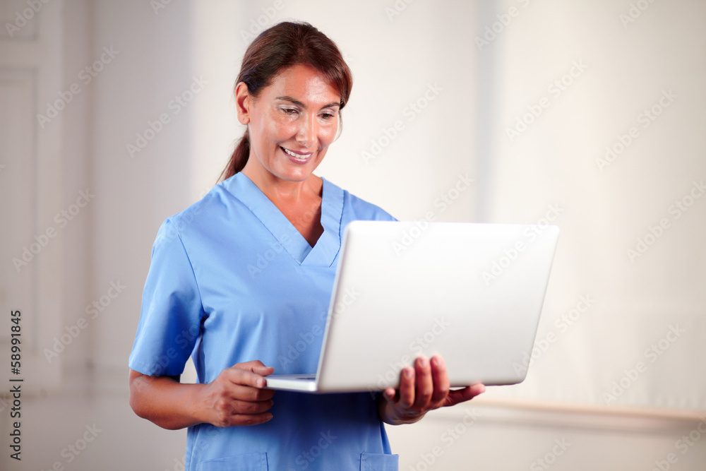 Beautiful hispanic doctor holding a laptop Beautiful hispanic doctor holding a laptop