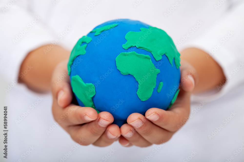 Our home - child holding earth made of clay Our home - child holding earth made of clay