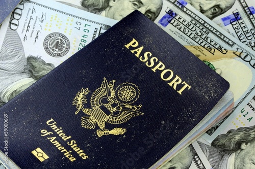United States travel passport with one hundred dollar bills
