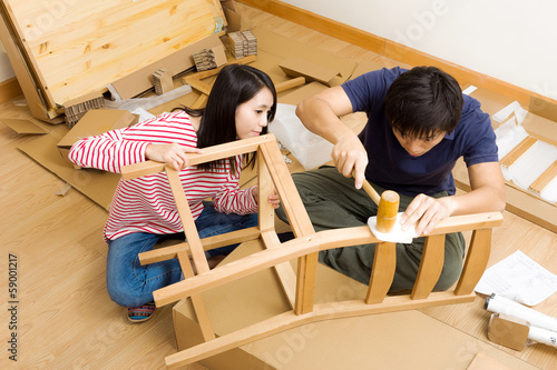 Asian couple assembling new chair