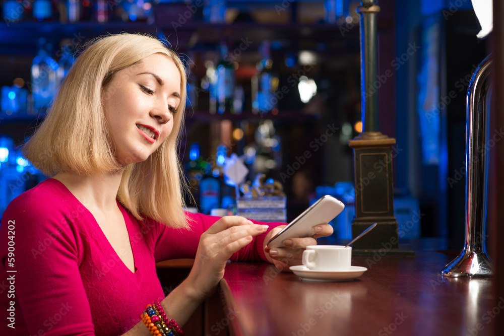 Fototapeta premium woman with a cup of coffee and cell phone